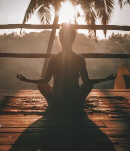 Person meditating peacefully outdoors after protecting their energy
